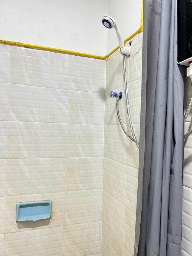 a shower with a shower curtain in a bathroom at Venn Hostel in Vientiane