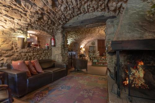 a living room with a fireplace in a stone wall at El Racó de Madremanya - Adults only in Madremanya