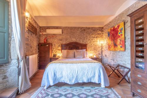 a bedroom with a bed in a stone wall at El Racó de Madremanya - Adults only in Madremanya