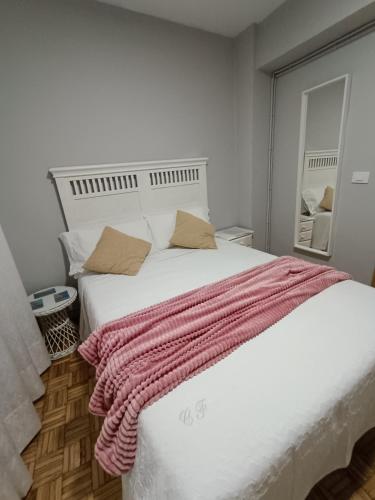 a bedroom with a large white bed with a pink blanket at Casa Filo in Redondela