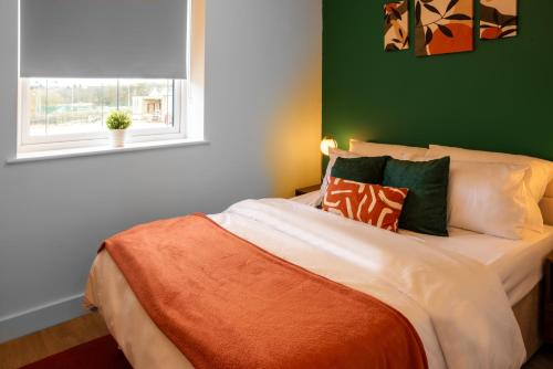 a bedroom with a bed with green walls and a window at Entire 1 Bedroom Flat Near Bradford Centre and Shipley in Bradford