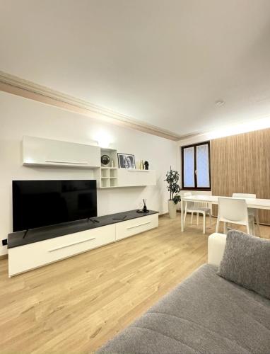 a living room with a large flat screen tv at Piazza San Giacomo - Elegant Apartment in Udine
