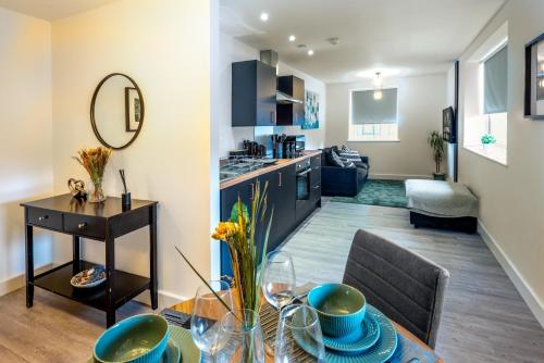 a living room with a table and a kitchen at Entire 1 Bedroom Flat Near Bradford Centre and Shipley in Bradford
