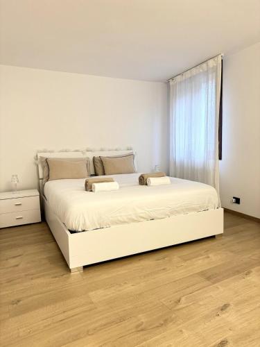 a white bedroom with a white bed and a window at Piazza San Giacomo - Elegant Apartment in Udine