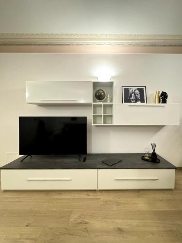 a large white entertainment center with a flat screen tv at Piazza San Giacomo - Elegant Apartment in Udine