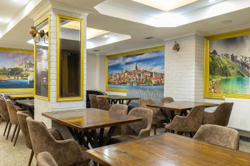 a restaurant with tables and chairs and paintings on the walls at Seher HOTEL in Istanbul