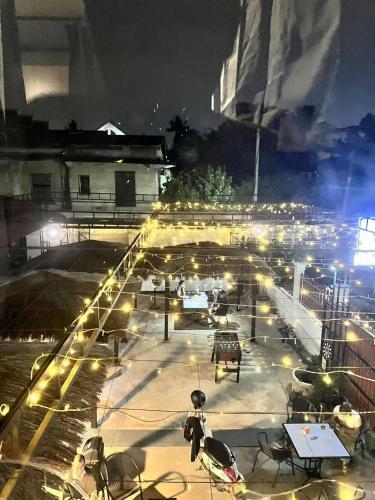 a parking lot with tables and chairs at night at Venn Hostel in Vientiane