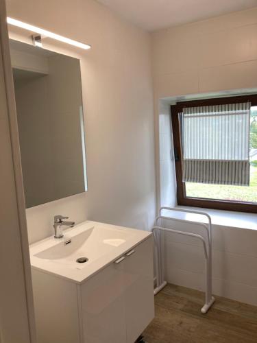 a white bathroom with a sink and a mirror at Au val des Ondines in Ondenval