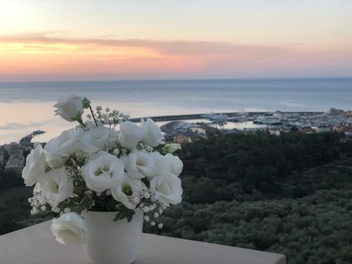 a white vase filled with white flowers on a ledge at Villa Laura in Pietra Ligure