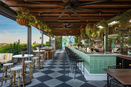 a restaurant with a bar with tables and chairs at Perry Lane Hotel, a Luxury Collection Hotel, Savannah in Savannah