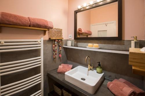 une salle de bain avec un lavabo et un miroir dans l'établissement Le Classé VIP vue féerique sur le Vieux Port, à La Ciotat