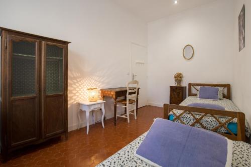 une chambre avec un lit, un bureau et une table dans l'établissement Le Classé VIP vue féerique sur le Vieux Port, à La Ciotat