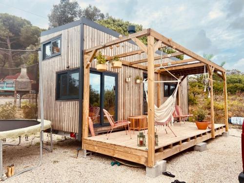 a tiny house with a hammock and a table at Tiny House Paulina de Luxe in Lourinhã