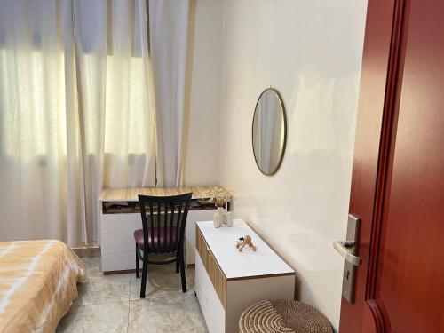 1 dormitorio con escritorio, 1 cama y 1 silla en Cozy Corner, en Ouakam