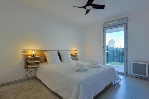 une chambre blanche avec un lit et une fenêtre dans l'établissement Casa Kenez - A 5min de la plage, à Cavalaire-sur-Mer