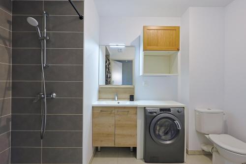 une salle de bain avec une machine à laver et un lavabo dans l'établissement Casa Kenez - A 5min de la plage, à Cavalaire-sur-Mer