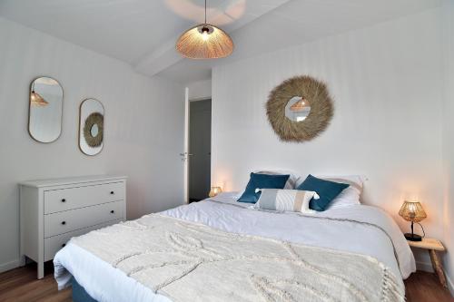 une chambre avec un lit et un miroir au mur dans l'établissement La Tranquilla - A quelques pas de la plage, à Saint-Cast-le-Guildo
