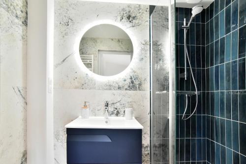 une salle de bain avec un lavabo et un miroir dans l'établissement La Tranquilla - A quelques pas de la plage, à Saint-Cast-le-Guildo