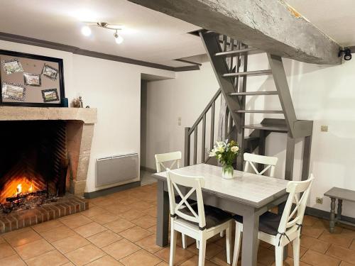 une salle à manger avec une table et une cheminée dans l'établissement Maison de charme avec jardin, animaux acceptés, WiFi - FR-1-491-388, à Saint-Lubin-en-Vergonnois