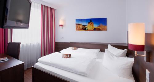 a hotel room with a bed and a tv at Hotel National in Bamberg