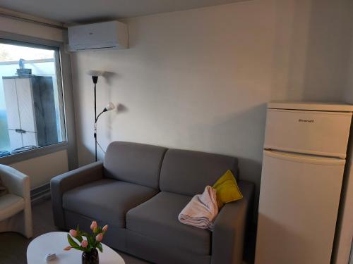 - un salon avec un canapé et un réfrigérateur dans l'établissement Nice Stay - Charmant 2p climatisé avec piscine et à 8mn des plages, à Antibes
