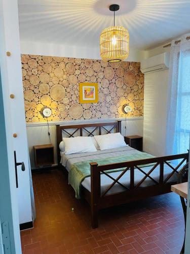 une chambre avec un lit et un lustre dans l'établissement Le 45- La Sauvagine, Appartement avec grande terrasse, 6 Couchages, 2 chambres, 3min de la plage, à Saintes-Maries-de-la-Mer