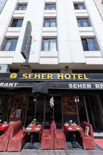 a restaurant with red tables and chairs in front of a building at Seher HOTEL in Istanbul