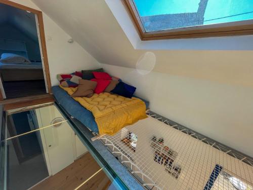 a small bed in a room with a window at Ty Heole House in Plouézec