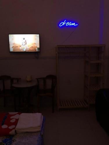 a room with a tv with a neon sign on the wall at Nhà nghỉ Vân Anh in Ấp Rạch Mẹo