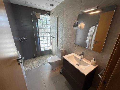 a bathroom with a sink and a toilet and a mirror at Villa Rey in Alcanar