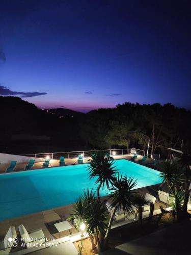 a large swimming pool at night with palm trees at Exceptional Luxury Villa A Masterpiece of Elegance and Comfort in Rafrāf