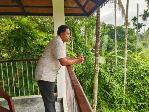 a man standing on the balcony of a house at Ananda Holiday Home in Ambalavayal
