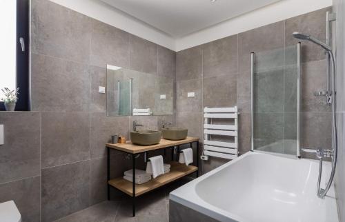 un bagno con due lavandini e una vasca di Villa Aurora a Dolac
