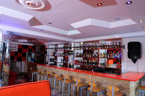 a bar in a restaurant with chairs and a tv at Yeoville Hotel in Johannesburg