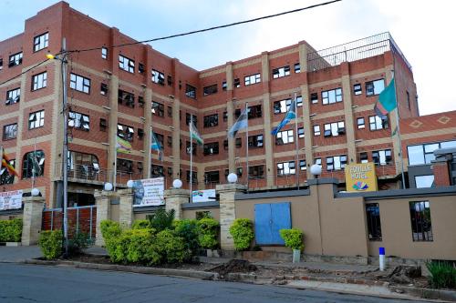 a large brick building with flags in front of it at Yeoville Hotel in Johannesburg