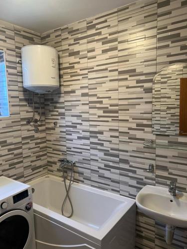 a bathroom with a bath tub and a sink at Resort Stari Bagrem Tvrdimici in Tvrdimići