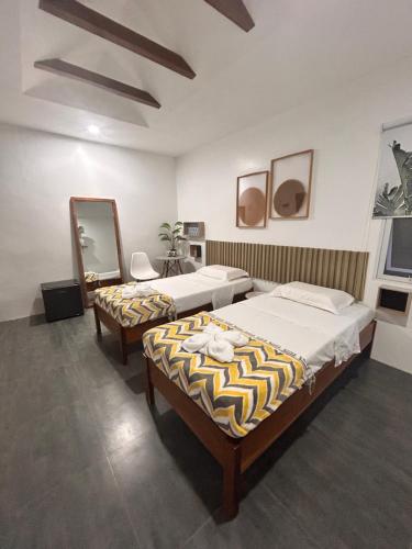 a bedroom with two beds and a mirror at White house panglao in Panglao