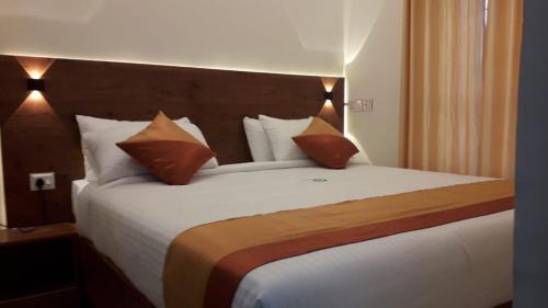 une chambre avec un grand lit blanc avec des oreillers dans l'établissement Attukad river side 4 Rooms Individual Cottage 'near attukad waterfalls' - Hall, 4bed room delux, falls view, located at tea etstae, à Devikolam