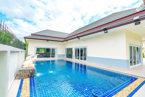a pool in the backyard of a home with a house at Royal Elephant Pool Villa in Na Jomtien