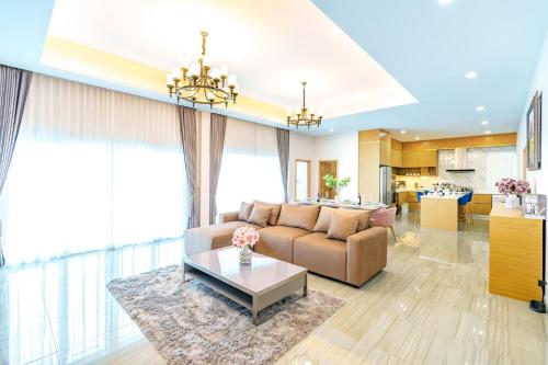 a living room with a couch and a table at Royal Elephant Pool Villa in Na Jomtien