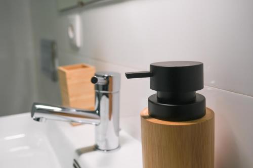 un lavabo con un dispensador de jabón negro. en Moniz Terrace, en Guimarães