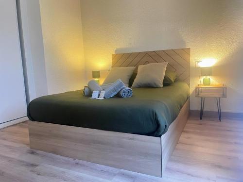 une chambre avec un grand lit avec une tête de lit en bois dans l'établissement 2 min Rois de majorque, Netflix, air conditioning, à Perpignan