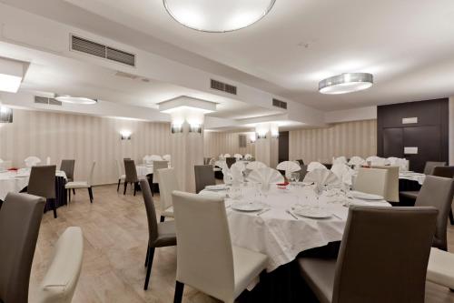 a dining room with white tables and chairs at Hotel Reina Cristina in Teruel