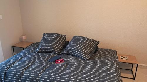 - un lit avec 2 oreillers et une télécommande dans l'établissement Chic vue Port !, à Leucate-Plage