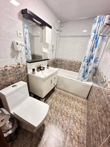 a bathroom with a toilet and a sink and a tub at Hotel Latif Samarkand in Samarkand