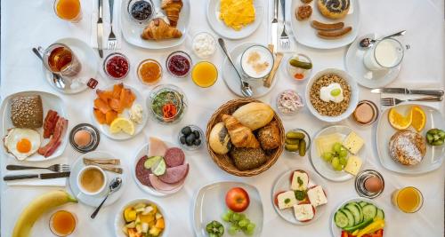 a white table topped with plates of breakfast foods at PLAZA Hotel Buchhorner Hof in Friedrichshafen
