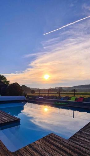 - un coucher de soleil sur la piscine dans l'établissement Gite ORCHIDEE au domaine les tournesols, à Mouzens