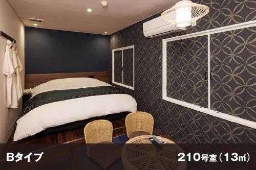 a bedroom with a bed and a window and chairs at Hotel Room in Miyazaki