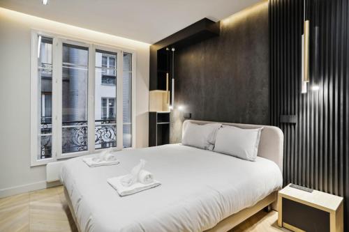 une chambre avec un grand lit blanc et une fenêtre dans l'établissement 515 Suite Miami - Luxury suite in Paris 6, à Paris