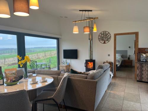 a living room with a couch and a table with a fireplace at Orchard Hideaway in Kelso